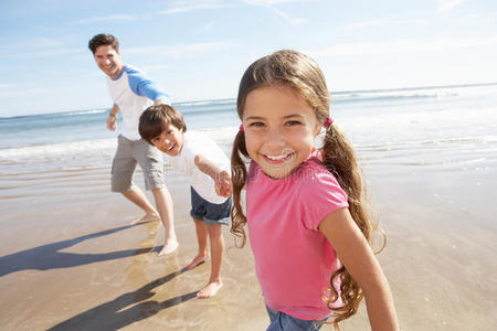 父亲和孩子们在海滩度假时玩得很开心