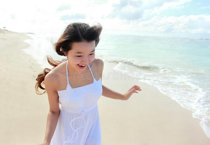 年轻快乐的女人在沙滩上奔跑