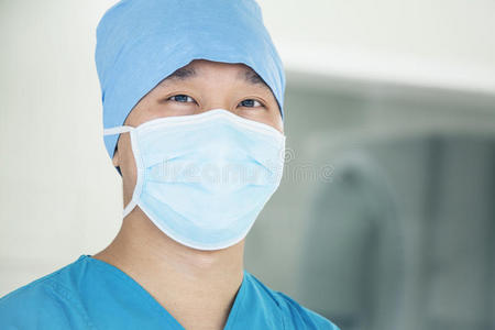 年轻外科医生在手术室戴口罩的照片，特写