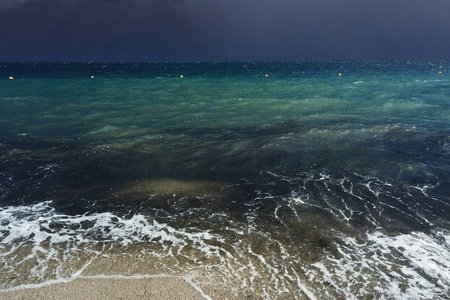 小波浪与泡沫在风暴的时候开始在晚上在海滩海岸的黑暗的海度假胜地
