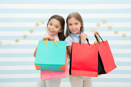 购物的孩子。小女孩在购物后带包裹的孩子。小女孩带纸袋的孩子们