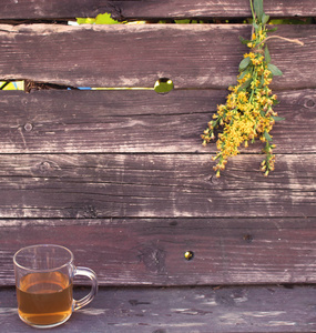 茶在玻璃杯上的木材背景与黄花草本植物, 加拿大黄帚, 治疗肾脏和泌尿道疾病, 改善新陈代谢