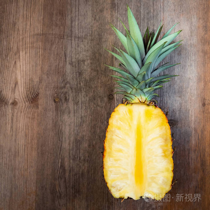 菠萝果切成一半的木质背景负空间.平方组成.多汁有机成熟和甜