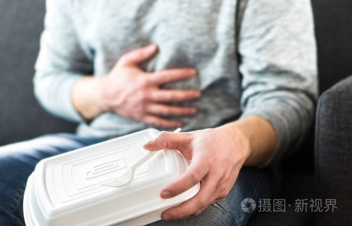 男子腹泻或食物中毒后, 不健康的垃圾快餐食品.男人吃
