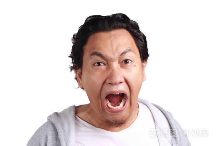 年轻亚裔男子的肖像穿着夹克愤怒和叫喊, 尖叫, 看着相机, 孤立的白色