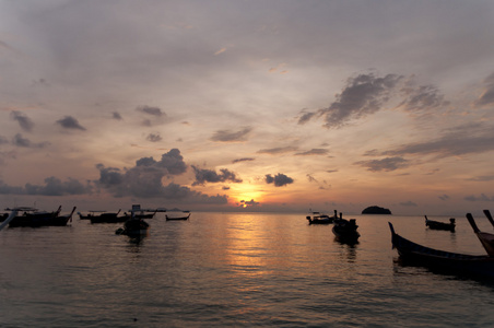 模糊的轮廓传统长尾船海上夕阳光