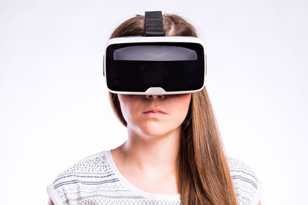 女子与虚拟现实的护目镜。工作室拍摄，灰色背景