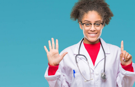 年轻的美国黑人医生妇女在孤立的背景显示和指向手指数六, 而微笑着自信和快乐