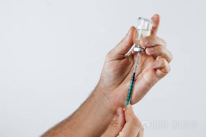 在一个人的手安瓿与药物和注射器的胰岛素特写.服药,治疗,注射的概念