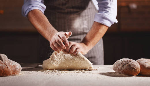 面包师的男性手捏道格