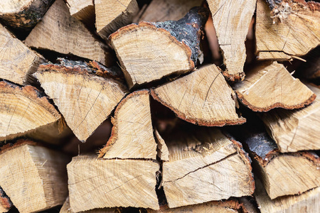 木柴叠墙。为冬天和寒冷的天气准备的木堆。干碎的橡木。木质背景纹理