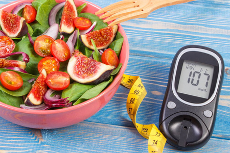 水果和蔬菜沙拉，用卷尺测量，概念的糖尿病，血糖仪减肥和健康的营养
