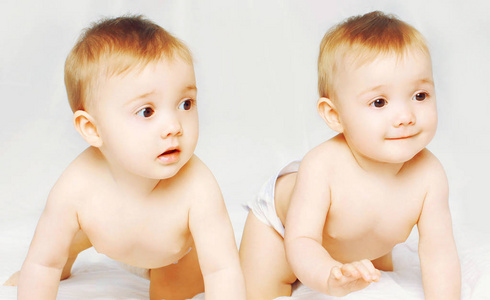 两个人因为开心双胞胎婴儿爬在床上特写