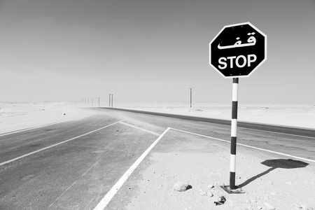 在阿曼附近旧沙漠的沥青空荡荡的街道和寂寞 