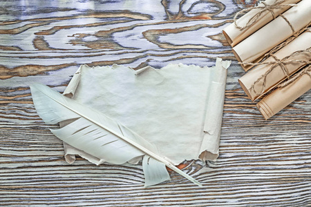 老式纸卷羊皮纸在木板上的羽毛