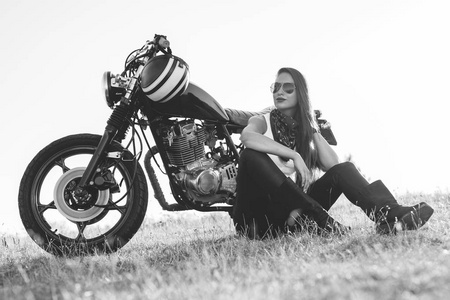 坐在她的摩托车美丽骑车女子黑白肖像