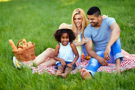 可爱的夫妇与他们的女儿在自然野餐照片的