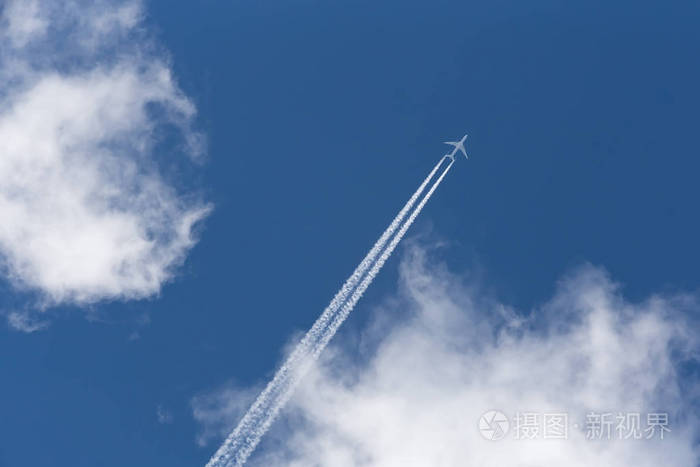 在多云的天空中的飞机留下了相反的踪迹