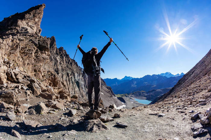 照片 徒步旅行者到达高山通行证;他张开双臂表示喜悦.