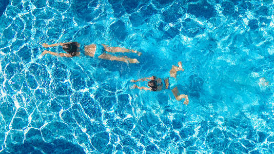 从上面的游泳池水中女孩的空中俯视, 活跃的儿童游泳, 孩子们在热带家庭度假的乐趣, 度假胜地概念