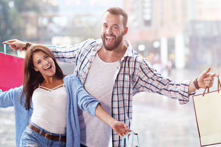 城市购物后带购物袋的幸福情侣肖像