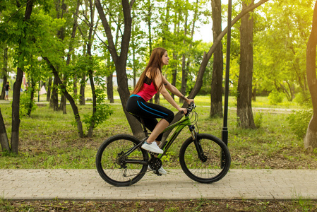 快乐的女孩骑自行车的人骑着一辆山地自行车外