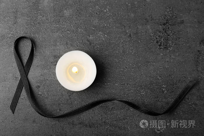 黑色丝带和蜡烛在灰色背景 顶部视图.葬礼符号