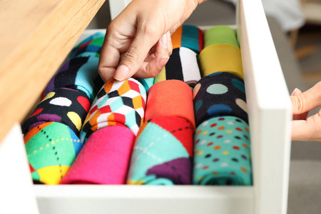 妇女打开抽屉与不同的五颜六色的袜子室内, 特写
