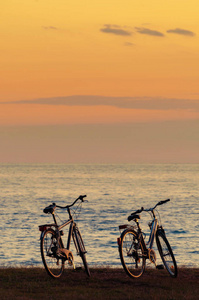 日落后海边的两辆自行车剪影