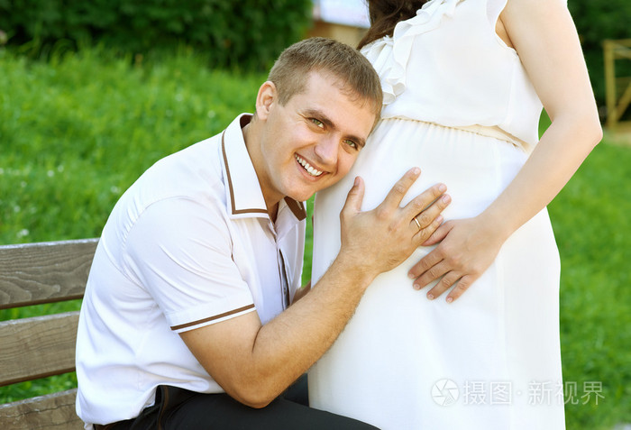 孕妇和丈夫,男人听着肚皮与交谈照片-正版商用图片0rwlld-摄图新视界