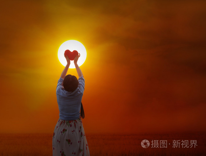 女人温柔地握住红色的心向太阳