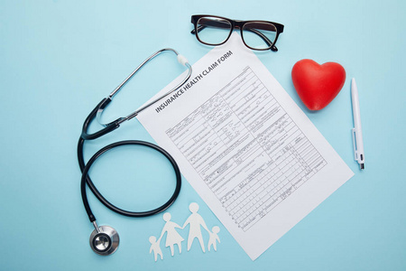 保险健康报销单眼镜剪纸系列红色心脏符号和蓝色听诊器的顶级视图