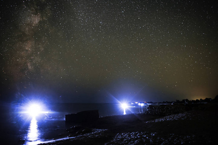 沙滩和海洋的海洋景观与夜间潜水员对星空的背景