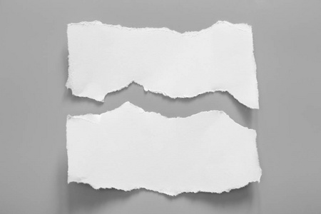 灰色背景上的白色撕裂纸。收纸 rip
