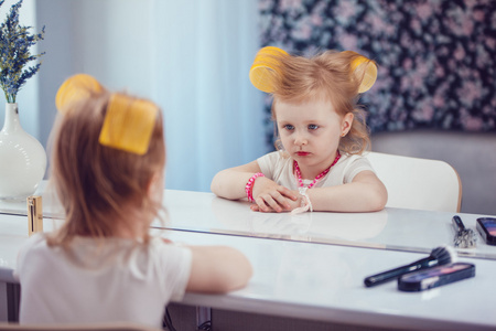 小女孩对着镜子做她的化妆