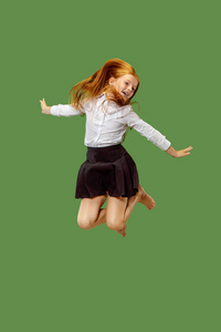年轻快乐高加索少女跳在空中, 在绿色背景隔离