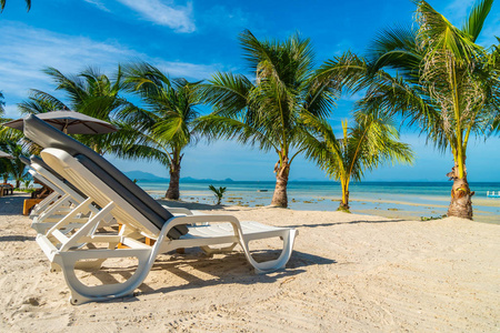美丽的户外海景与雨伞和椅子围绕椰子棕榈树的旅行和度假