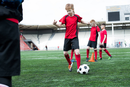 青年足球队在体育场内练习的全长肖像聚焦于男主角球在前景, 复制空间