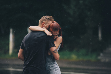 美丽的夫妇在雨中拥抱