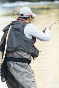 在美丽的河中使用 flyfishing 杆的飞钓者