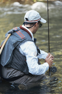 在美丽的河中使用 flyfishing 杆的飞钓者