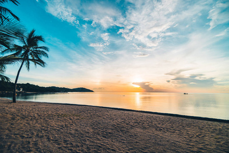 在日落时分的热带天堂岛海滩和海洋与椰子棕榈树度假和度假