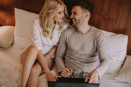 爱夫妇上网冲浪在笔记本电脑在家里的床上