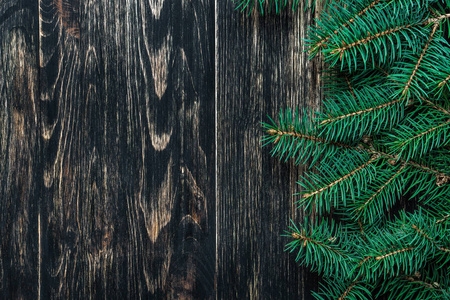云杉树枝上的黑色老式木质背景。圣诞理念