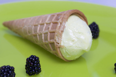用华夫饼垫的冰淇淋。躺在浅绿色的盘子里。附近躺着几浆果的黑莓
