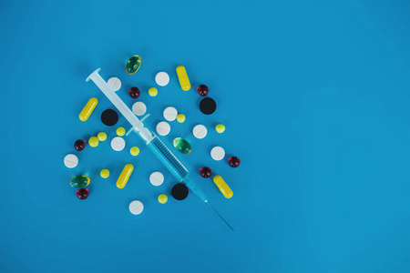 医学药片。彩色药丸和胶囊在蓝色背景。药剂主题, 胶囊丸与药物抗生素包装