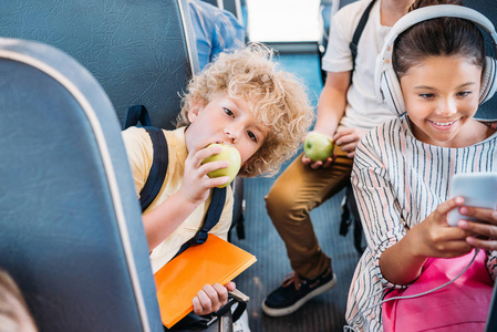 可爱的小男孩吃苹果, 而乘坐校车与同学