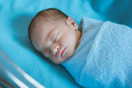 刚出生的婴儿在睡眠时亚洲覆盖着蓝色的布