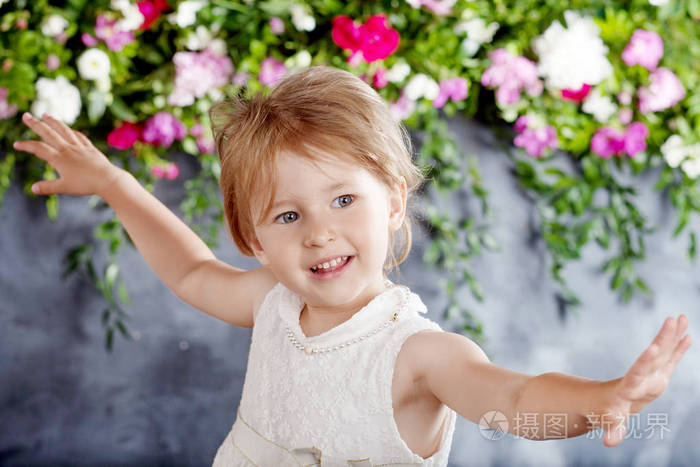 可爱的小女孩的肖像与花.女孩大笑和玩耍