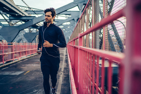 运动的人与肌肉的身体运行横跨城市桥梁与瓶子在手, 年轻的慢跑运动员在户外享受有氧运动和锻炼, 欧洲选手努力实现目标